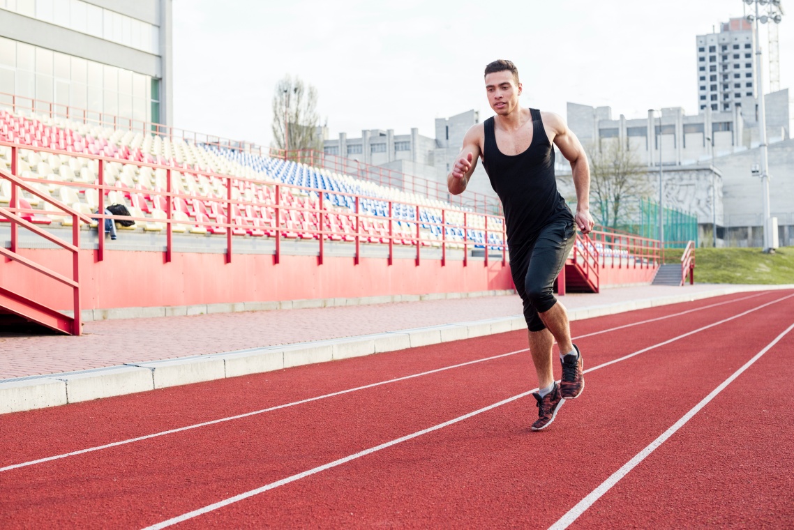 hhts-portrait-fitness-young-male-athlete-running-race-track-stadium